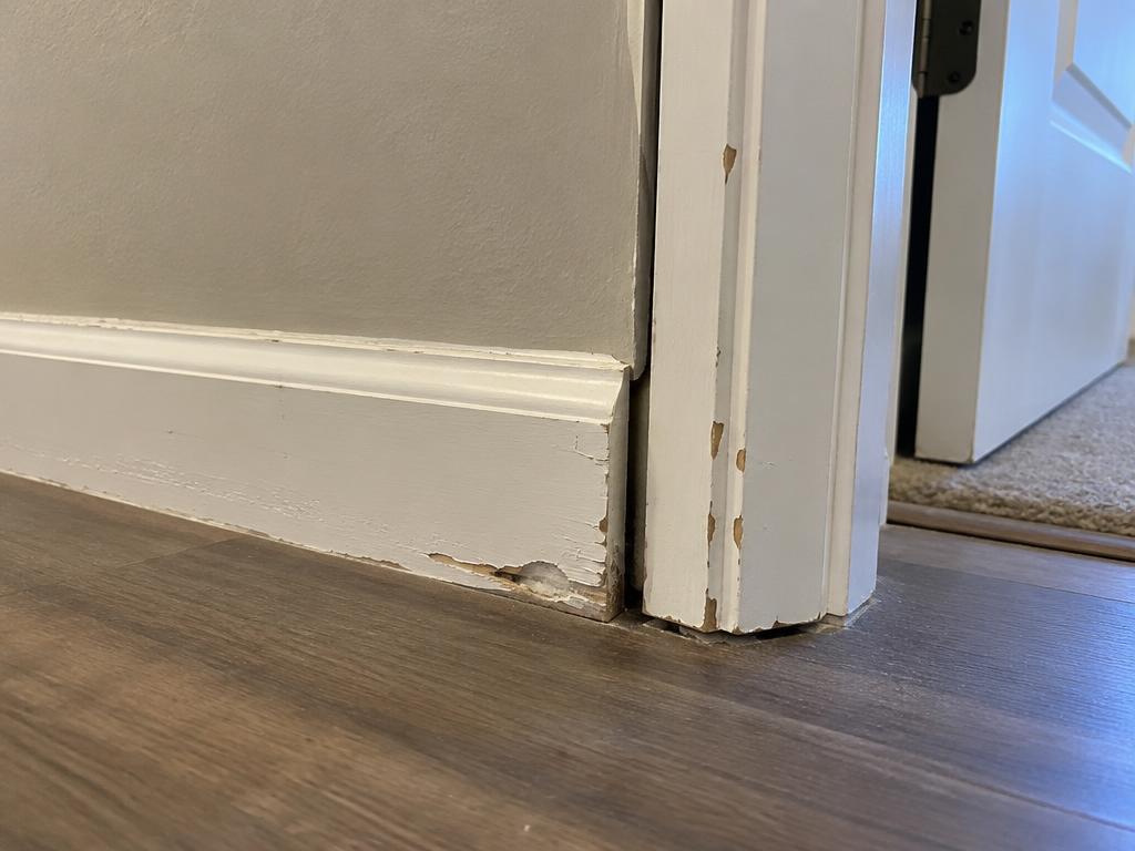 Before: Chipped baseboard and gapped casing